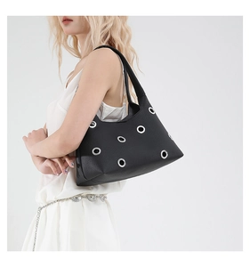 Detail of black pebbled leather underarm bag with decorative silver metal rings