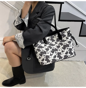 Dettaglio borsa shopper maculata con manici in pelle e decorazione ad anello argento