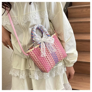 Detailed texture of woven crossbody bag with lace bow decoration and pink rope strap