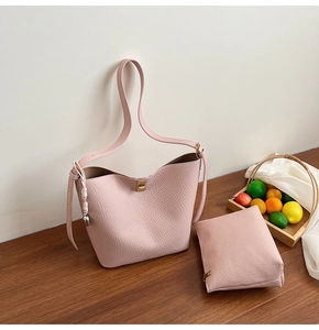 Detail of pink lychee grain shoulder bag with matching pouch and gold hardware