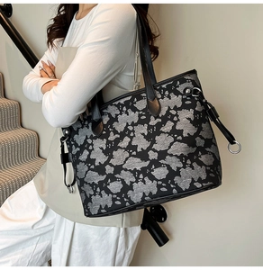 Dettaglio di una grande borsa tote con motivo floreale astratto e manici in pelle