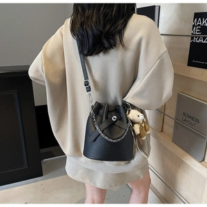 Fashionable black bucket bag with lychee pattern leather and cute teddy bear charm