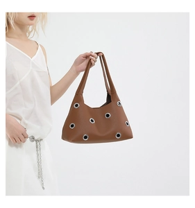 Nahaufnahme der braunen Ledertasche mit großen silbernen Ösen und feiner Litschi-Maserung