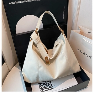 Detail of beige canvas tote bag with knot strap and leather trim in stylish gift box