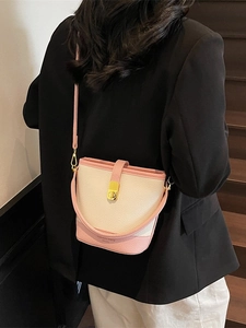 Sac seau bicolore rose et blanc en cuir avec fermoir doré porté en bandoulière
