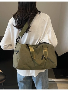 Olive green multifunctional fitness travel bag shown worn as a large crossbody shoulder bag