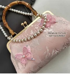 Detail of vintage pink embroidery bag with bamboo handle, pearl strap and floral patterns