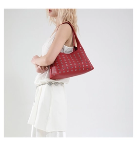 Detailaufnahme einer roten Hobo-Tasche aus Leder mit Metallösen an einem Modell