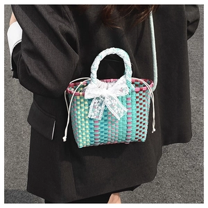 Close-up of multicolor woven crossbody bag with lace bow and white drawstring detail