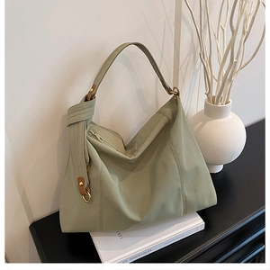 Detail view of large sage green tote bag with wide shoulder strap and gold zipper