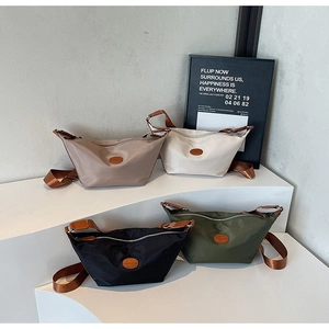 Detailed row of Oxford fabric crossbody bags in four colors on a minimalist display