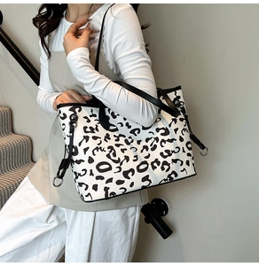 Dettaglio della borsa tote leopardata bianca con sottili spalline nere e anello in metallo