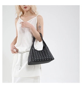 Detail of black lychee grain leather underarm bag with silver metallic rivets and eyelets