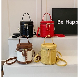 Detail of colorful cylinder vanity bags with bear embossing and adjustable straps