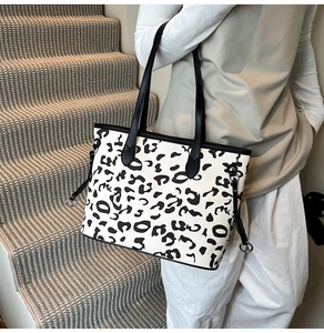 Dettaglio della borsa tote leopardata con manici neri indossata sulle scale
