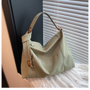 Detail of mint green tote bag featuring metal ring hardware and smooth nylon fabric