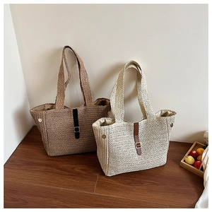 Détail de sacs cabas en paille tressée marron et beige avec boucles en cuir élégantes