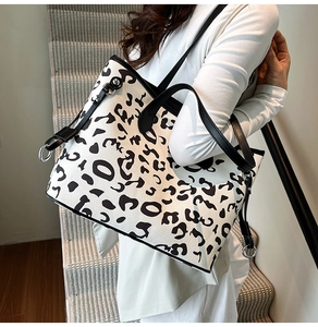 Dettaglio borsa tote bianca leopardata con spalline nere e anelli metallici argentati