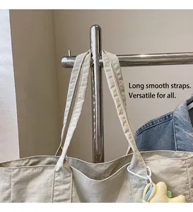 Detail of beige tote bag fabric texture with long straps and star plush pendant
