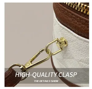 Detailed macro view of white pebble leather bucket bag with gold hardware and brown trim