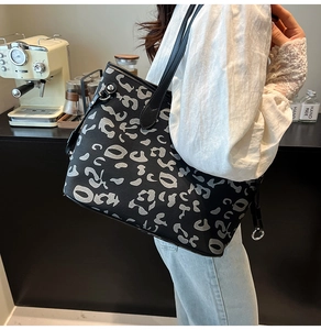 Dettaglio di una grande borsa tote nera con stampa leopardata astratta grigia e bianca