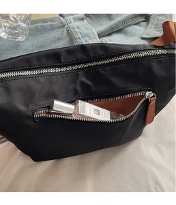 Detail view of black oxford nylon bag featuring silver zippers and leather pullers