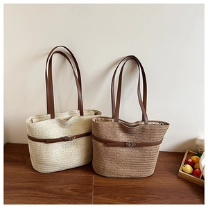 Detail of woven straw tote bags with leather straps and metal buckles for summer