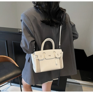 Detail of white lychee leather and beige fabric patchwork on a stylish handle bag