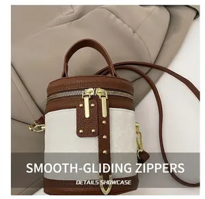 Detail shot of smooth dual metal zippers and brown lychee grain leather on a vintage bag