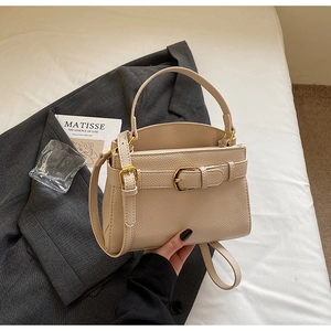 Détail du sac à main en cuir grainé crème avec boucle dorée et bandoulière élégante