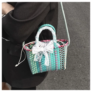 Detail of colorful hand-woven bucket bag with lace bow and drawstring inner lining