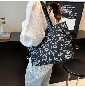 Dettaglio di una grande borsa tote nera con stampa leopardata grigia e tracolle in pelle