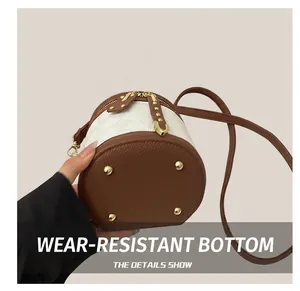 Detail view of mini bucket bag showing quilted texture and wear-resistant rivet bottom