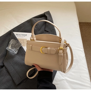 Détail d'un sac à main en cuir beige grainé avec bandoulière et boucle métallique