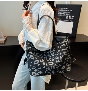 Dettaglio della borsa tote grande con stampa astratta bianca e nera e anello in argento