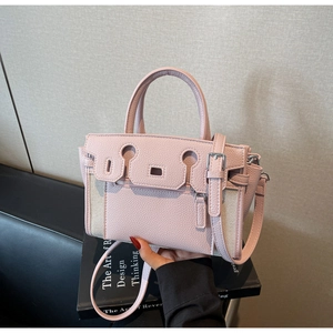 Detail of pink lychee leather and beige canvas bucket bag with silver buckle hardware