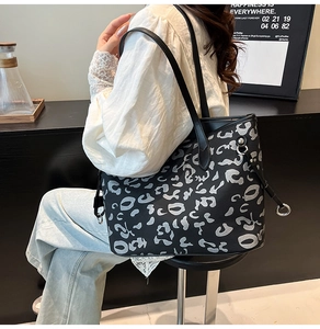 Grande borsa tote in pelle con stampa leopardata argento portata a spalla da donna