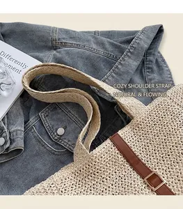Détail de la texture d'un sac cabas en paille tissée avec accents en cuir marron