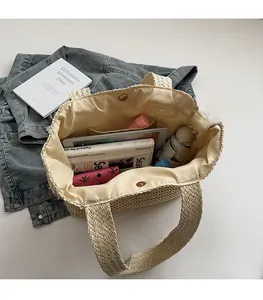 Intérieur spacieux d'un sac cabas en paille beige avec de la place pour des accessoires