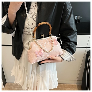 Detailed view of pink jacquard shell bag featuring bamboo handle and 3D butterfly decor