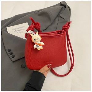 Detail of red bucket bag with litchi grain leather and a cute bunny pendant charm