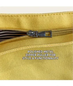 Close-up of bright yellow canvas tote bag with durable metal zipper and striped lining