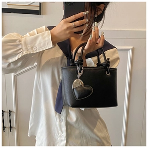 Detailed mirror selfie of black litchi pattern bucket bag with heart pendant
