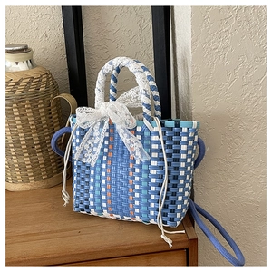 Close-up of blue and white woven handbag with lace bow detail and resin texture