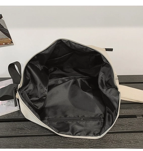 Interior view of spacious nylon bag featuring black lining and zippered inner pocket