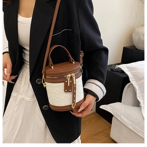 On-body shot of a chic brown and white bucket bag with geometric texture and tassel details