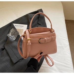 Vue détaillée du sac à main rose grainé avec boucle dorée et bandoulière réglable