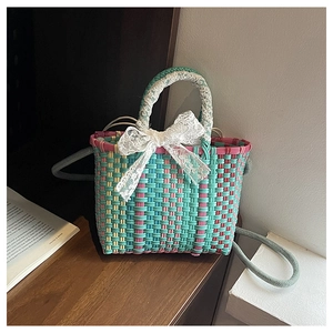 Detailed shot of woven handbag featuring white lace bow and elegant lace-wrapped handles