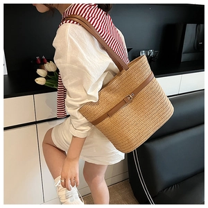 Detailed texture of woven straw tote bag with brown leather straps for summer beach