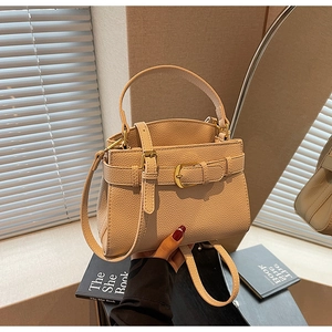 Détail du sac à main en cuir grainé beige avec boucle dorée et bandoulière